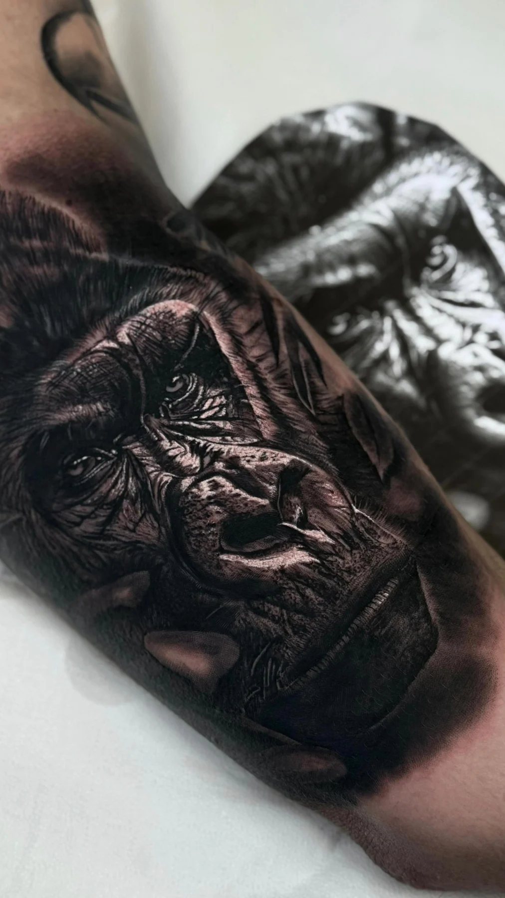 Black and grey cover up in progress on the arm