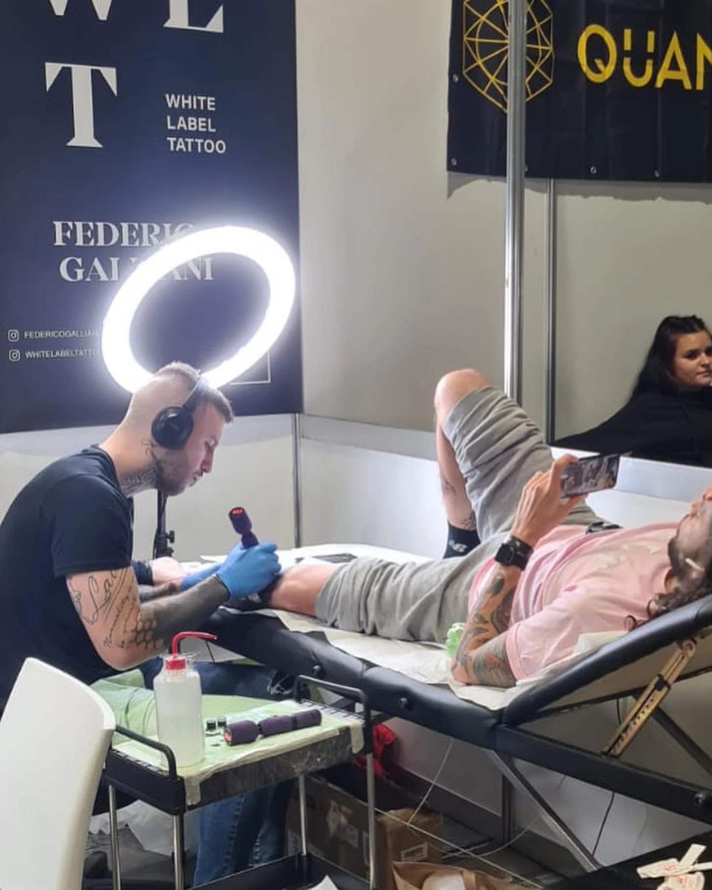Federico Galliani tattooing at his convention booth under the White Label Tattoo banner
