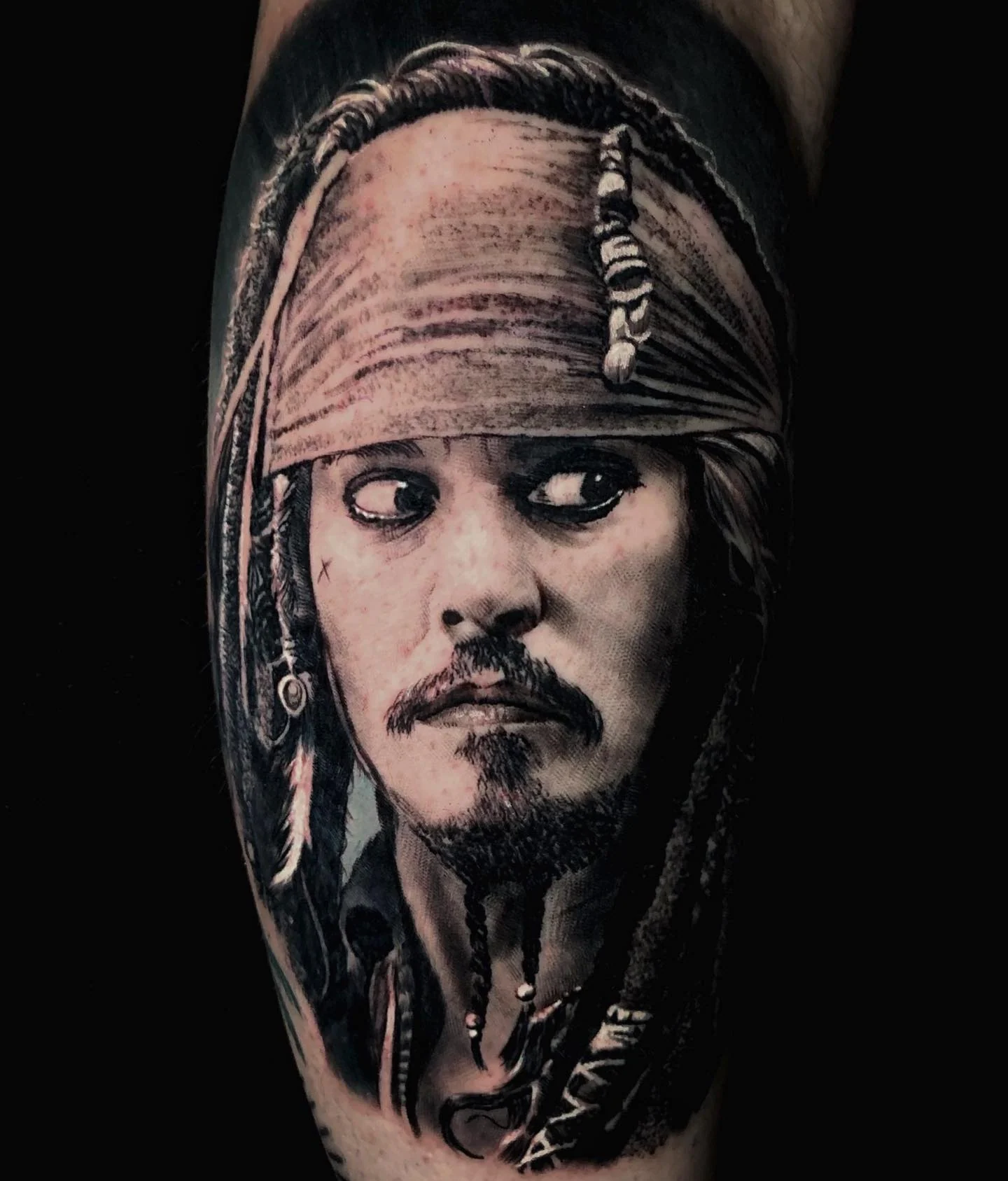 Black and grey portrait of Jack Sparrow on the upper arm