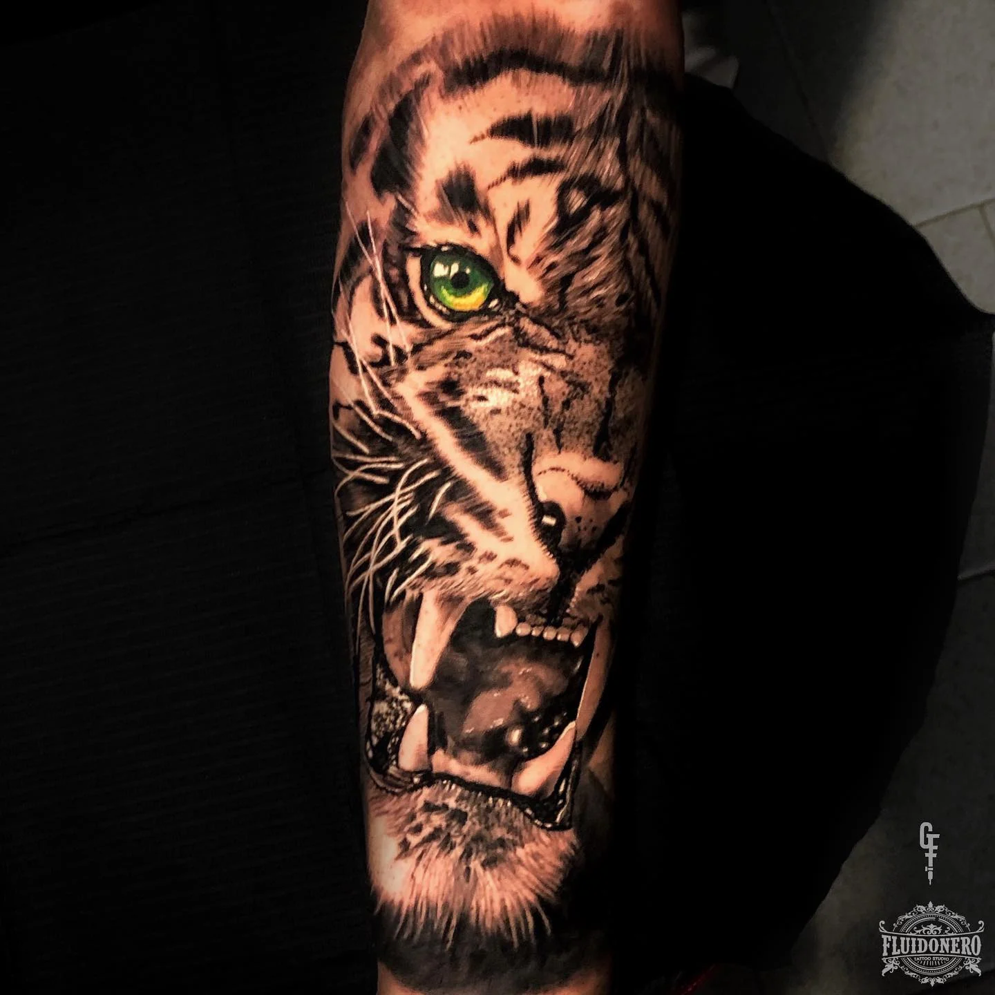 Realistic tiger with one green eye on the forearm